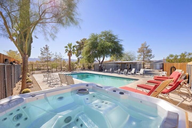 view of pool with a patio and an outdoor hot tub