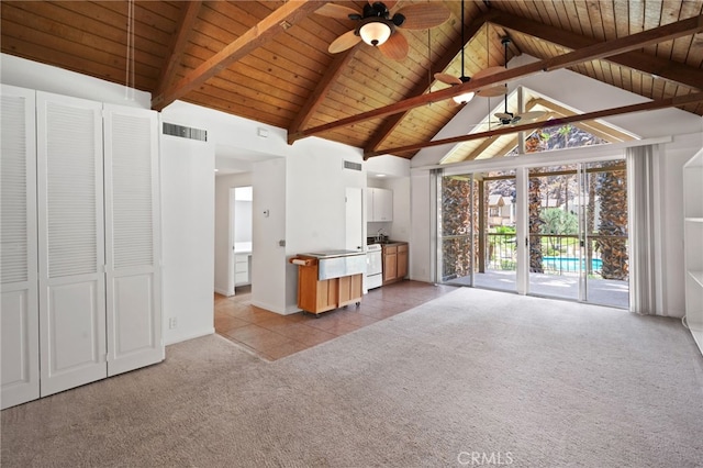 unfurnished living room featuring beamed ceiling, ceiling fan, light colored carpet, and wooden ceiling