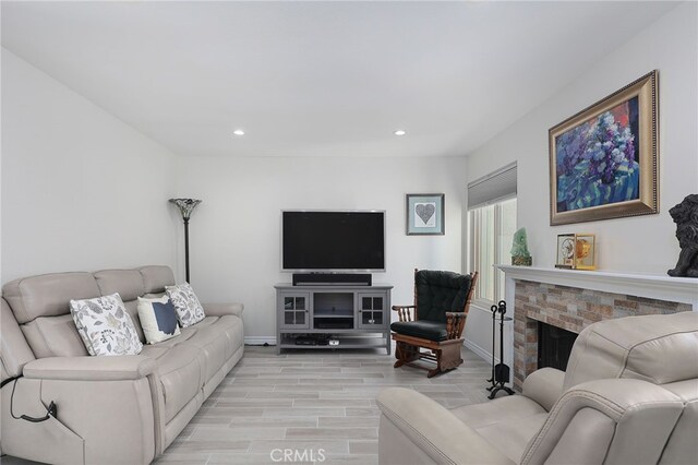 living room featuring a fireplace and light wood-type flooring