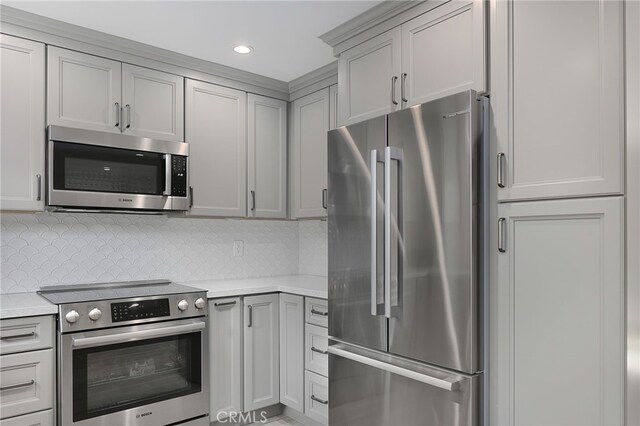 kitchen with gray cabinetry, appliances with stainless steel finishes, and decorative backsplash