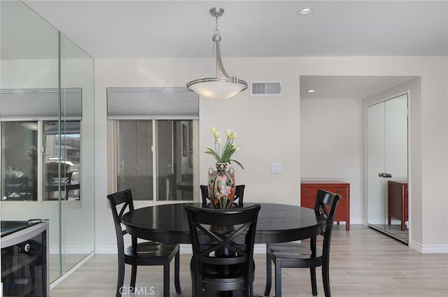 dining area with light hardwood / wood-style flooring and beverage cooler