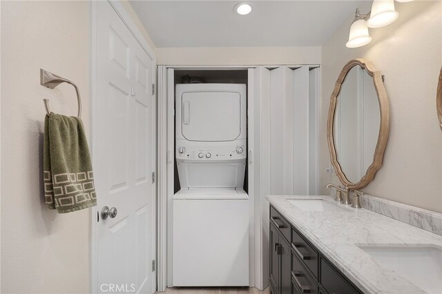 bathroom featuring stacked washer / dryer and vanity