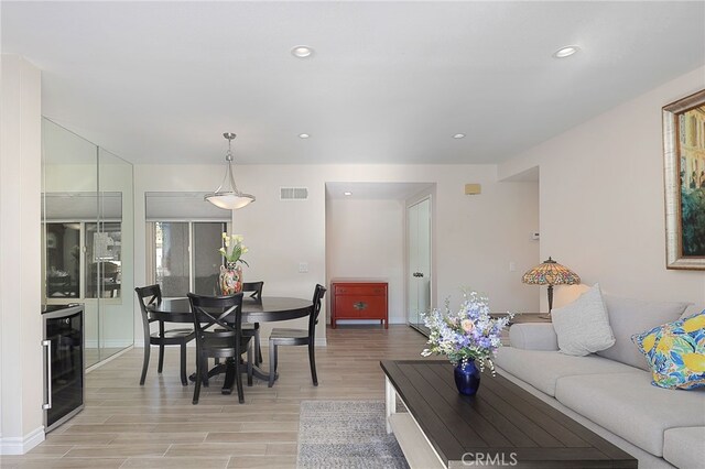 living room with light wood-type flooring and beverage cooler