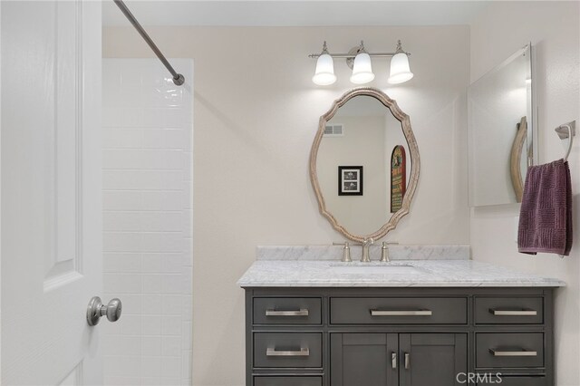 bathroom with walk in shower and vanity