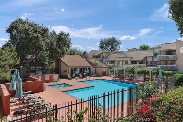 community pool featuring a patio area, a residential view, and fence