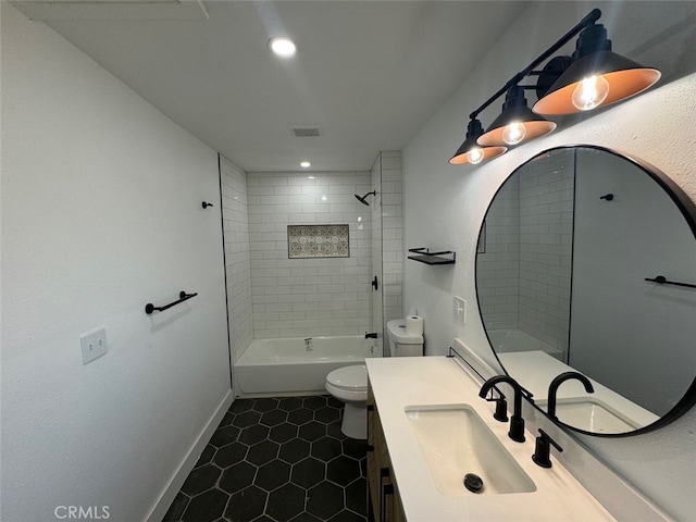 full bathroom featuring toilet, tile patterned flooring, tiled shower / bath combo, and vanity