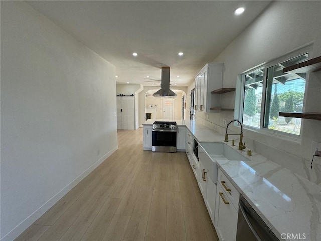 kitchen with white cabinets, light stone counters, sink, and appliances with stainless steel finishes