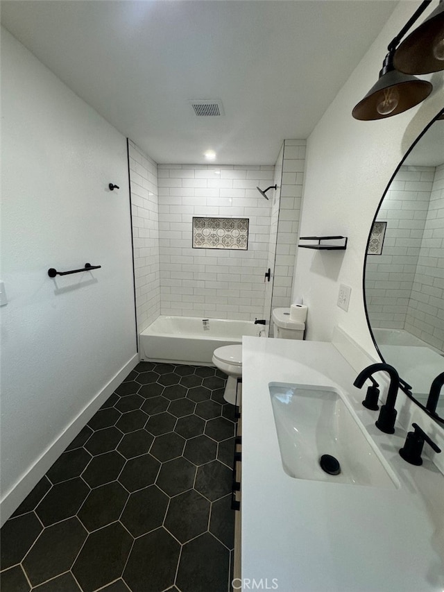 full bathroom featuring tile patterned floors, toilet, vanity, and tiled shower / bath combo