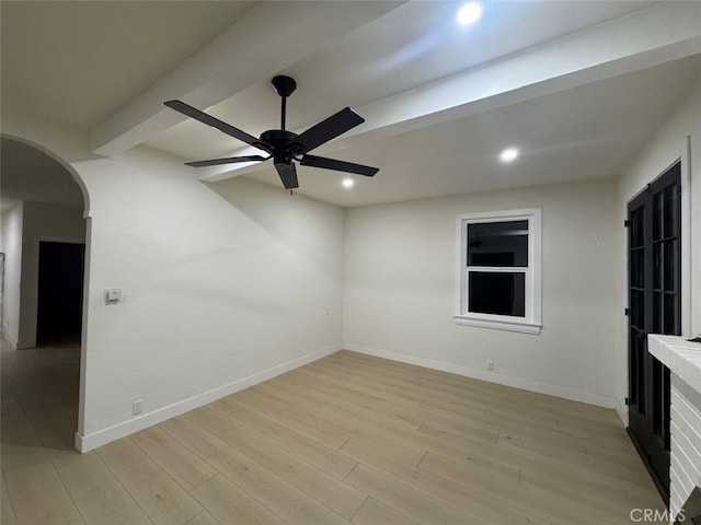 spare room with light wood-type flooring, ceiling fan, and beam ceiling