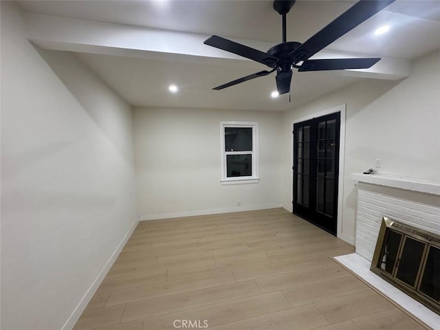 interior space with ceiling fan, a fireplace, and light hardwood / wood-style flooring