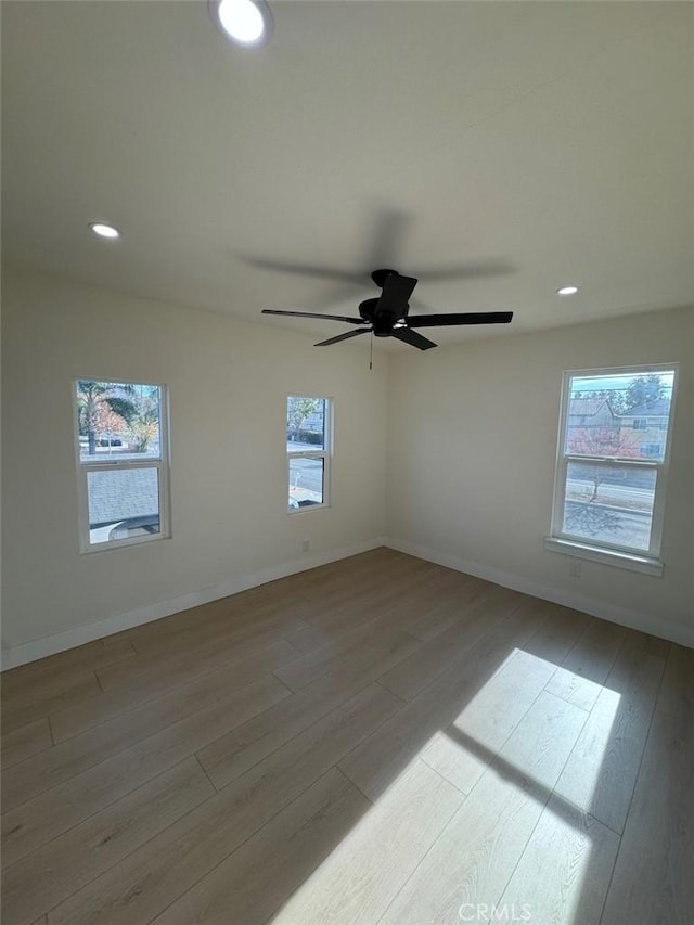 empty room with ceiling fan and light wood-type flooring