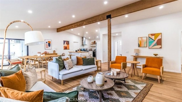 living room featuring vaulted ceiling with beams and light hardwood / wood-style flooring