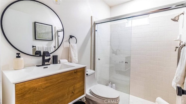 bathroom featuring toilet, vanity, and walk in shower