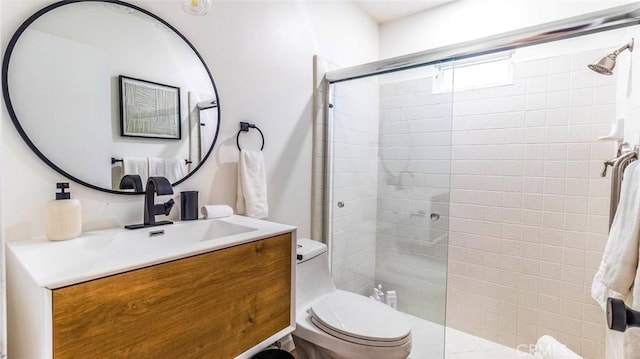 bathroom featuring vanity, toilet, and walk in shower