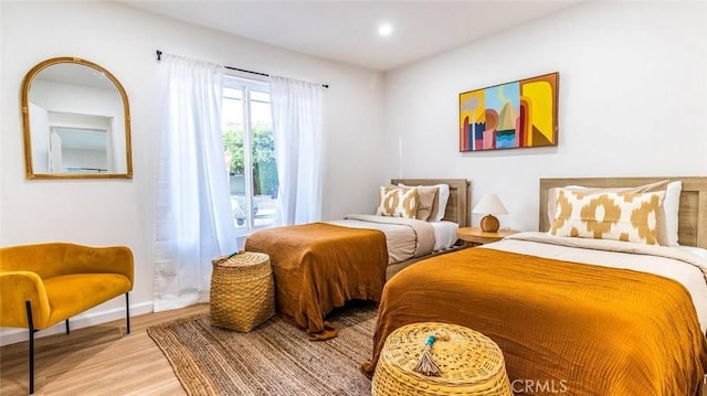 bedroom featuring access to exterior and light wood-type flooring