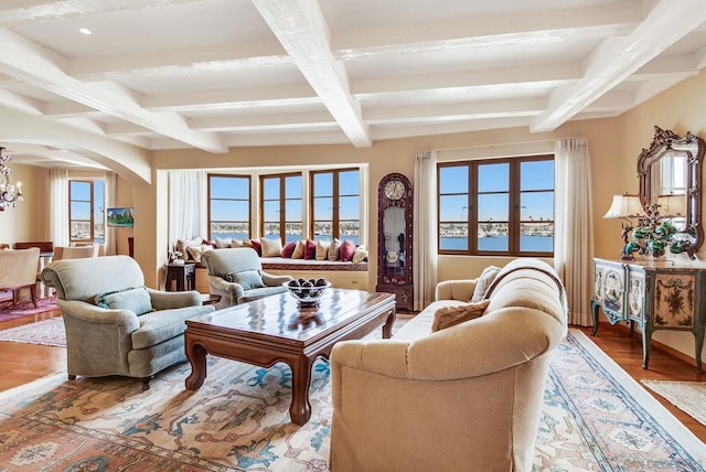 living room featuring hardwood / wood-style floors, a water view, an inviting chandelier, and beam ceiling