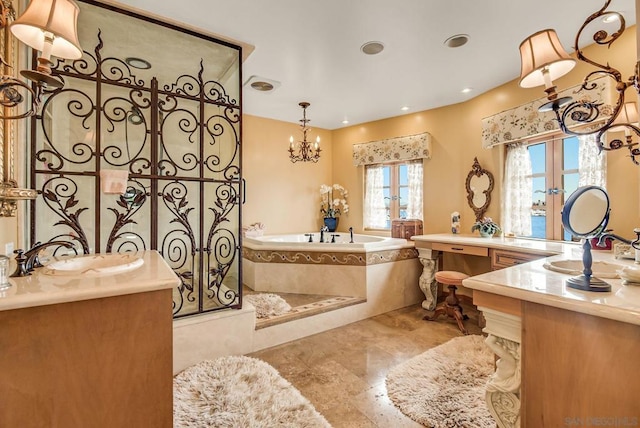 bathroom with vanity, tiled tub, a wealth of natural light, and french doors