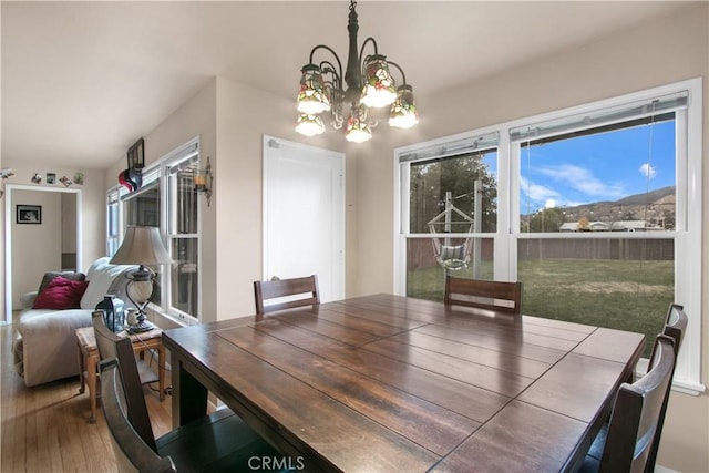 dining space with hardwood / wood-style floors and a chandelier