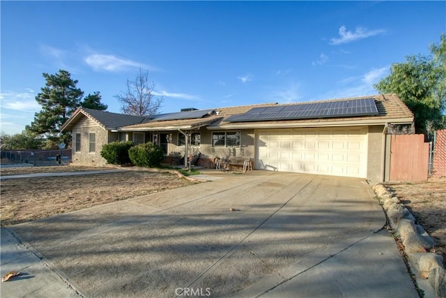 single story home with solar panels and a garage