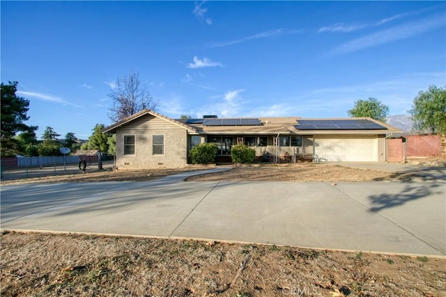 ranch-style home with solar panels and a garage