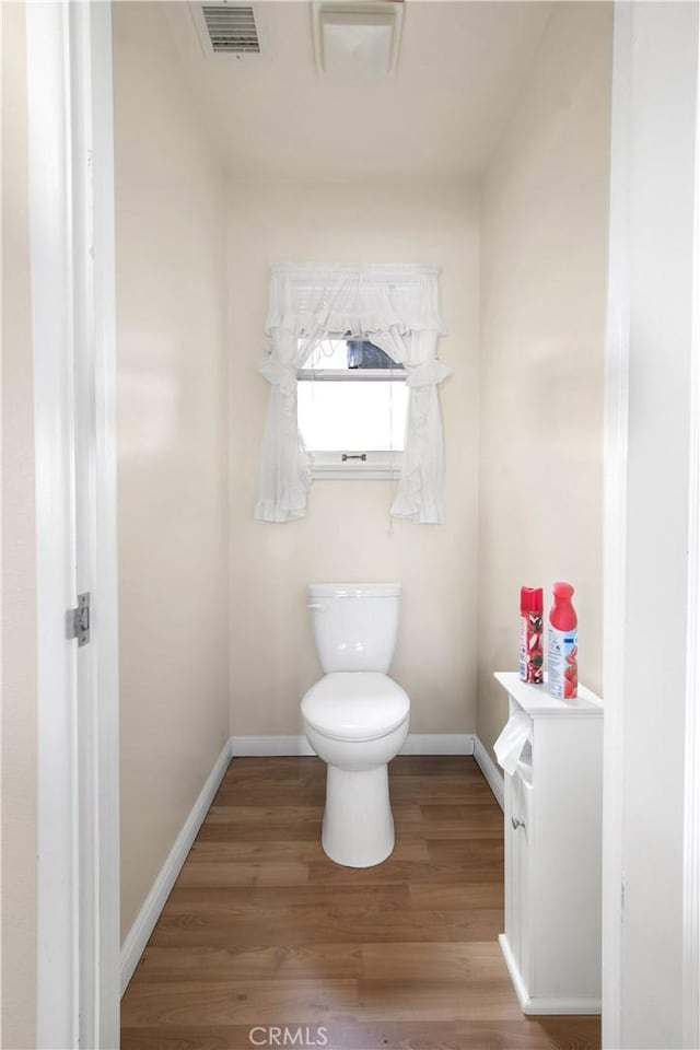 bathroom featuring toilet and wood-type flooring