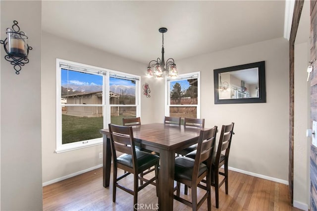 dining room featuring wood-type flooring and an inviting chandelier