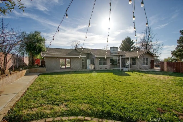 rear view of property featuring a lawn