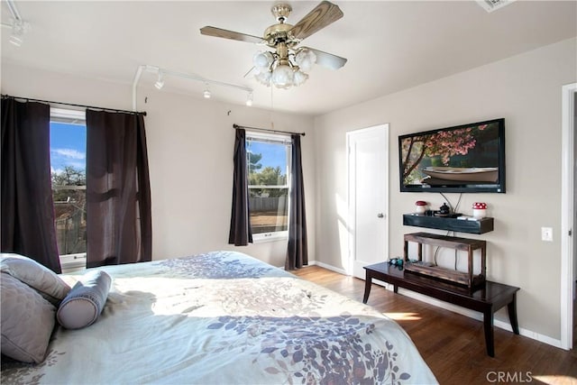 bedroom featuring hardwood / wood-style floors, track lighting, and ceiling fan