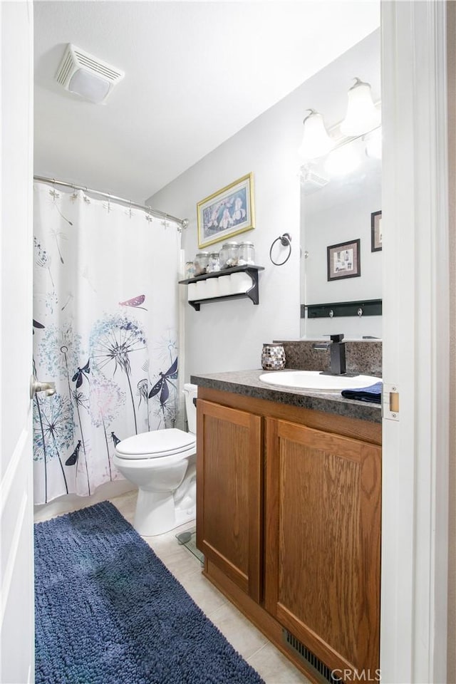 bathroom with tile patterned flooring, vanity, and toilet