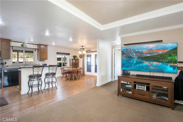 living room featuring french doors, light hardwood / wood-style floors, ceiling fan, and crown molding