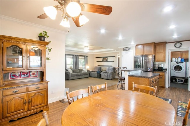 dining area with ceiling fan, crown molding, and light hardwood / wood-style flooring