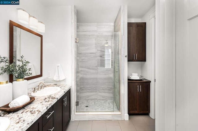 bathroom featuring vanity, tile patterned flooring, and a shower with door