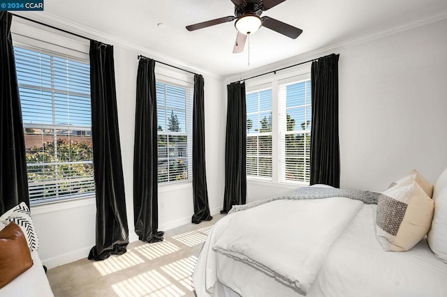 bedroom featuring ceiling fan, light carpet, and crown molding