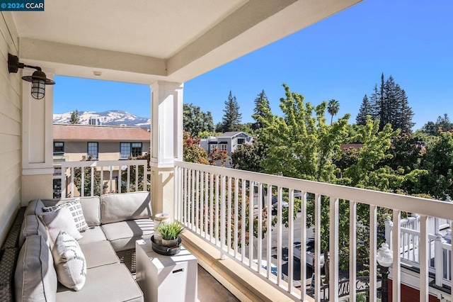 balcony featuring a mountain view and an outdoor living space