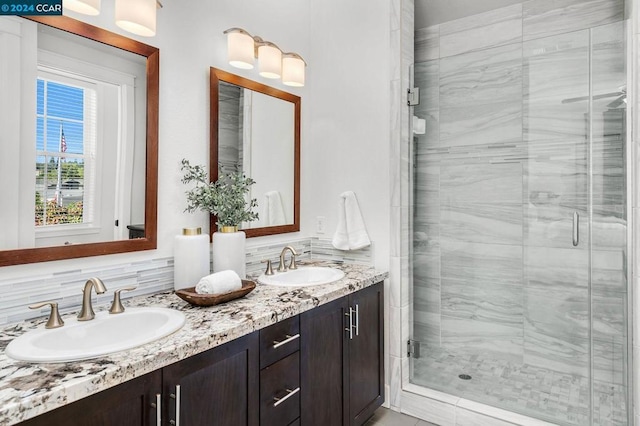 bathroom featuring an enclosed shower, vanity, and tasteful backsplash