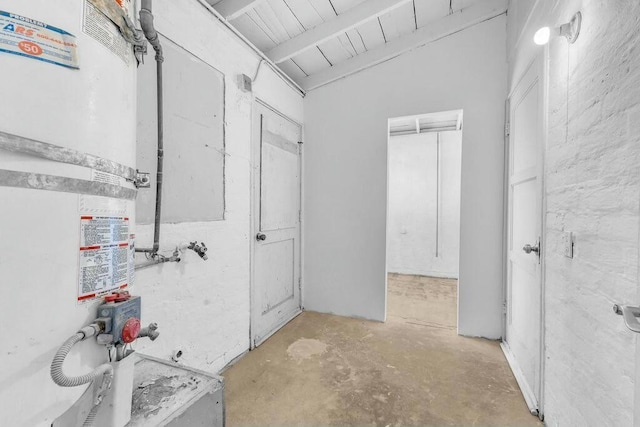 bathroom with heating unit, lofted ceiling with beams, and concrete flooring