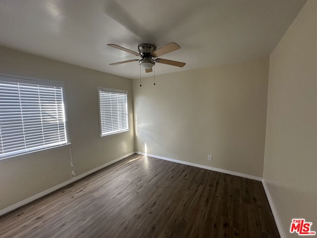 unfurnished room with ceiling fan and dark wood-type flooring