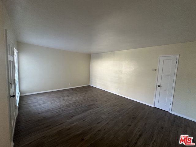 unfurnished room with dark wood-type flooring