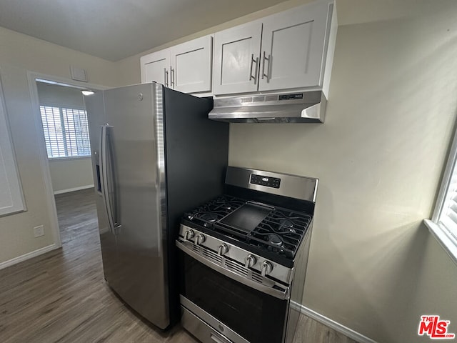 kitchen with white cabinets, stainless steel appliances, and hardwood / wood-style flooring