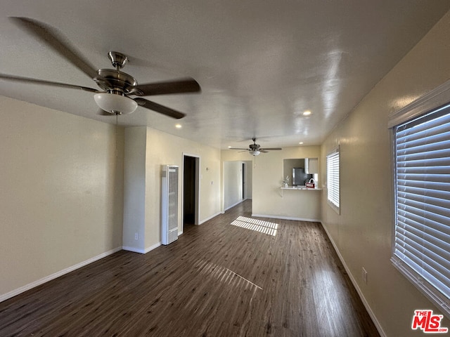 unfurnished living room with ceiling fan and dark hardwood / wood-style flooring