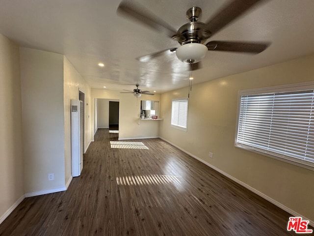 unfurnished living room with dark hardwood / wood-style floors and ceiling fan