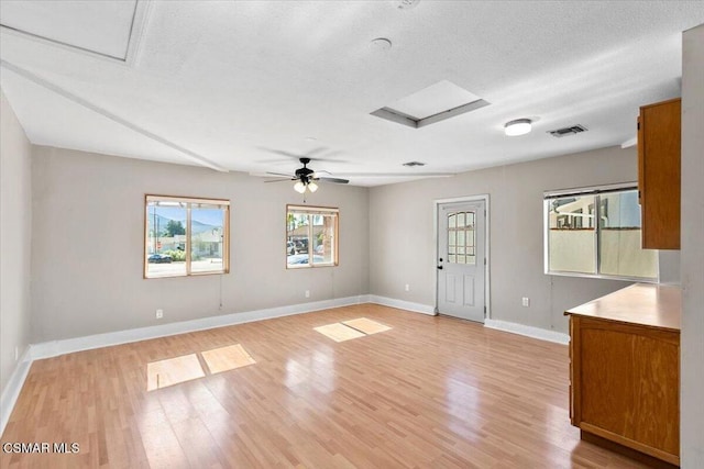 interior space with a textured ceiling, light hardwood / wood-style flooring, and ceiling fan