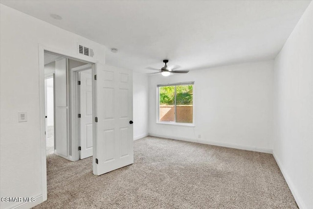 carpeted spare room with ceiling fan