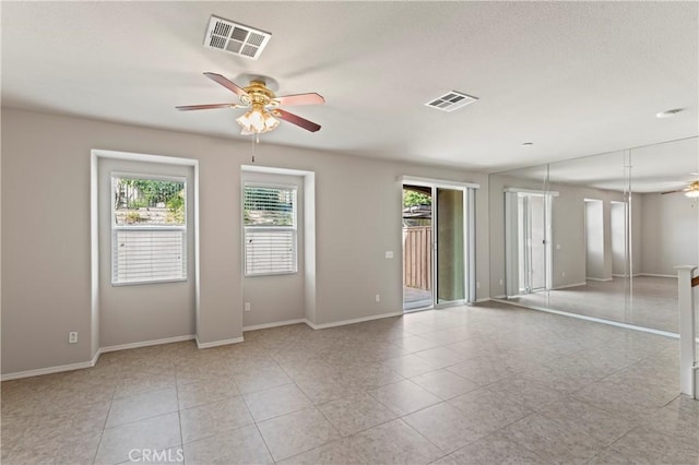 tiled spare room featuring ceiling fan