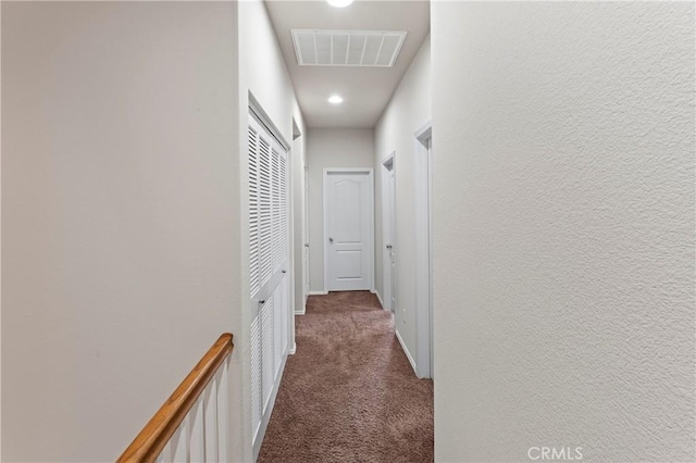 hallway featuring dark carpet