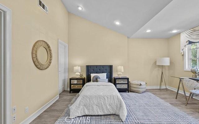 bedroom featuring hardwood / wood-style flooring and lofted ceiling