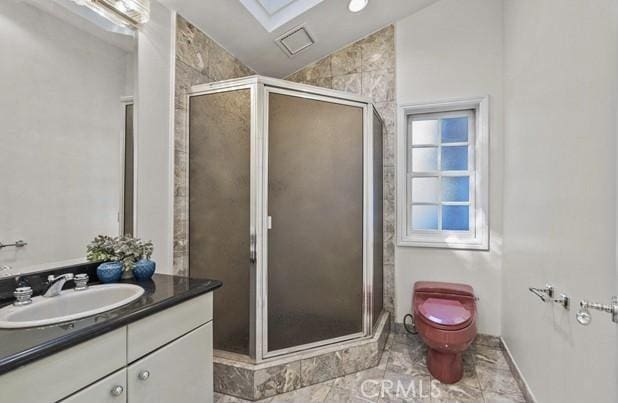 bathroom with vaulted ceiling with skylight, a shower with door, and vanity