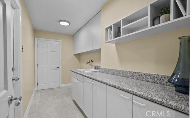 washroom with sink and cabinets