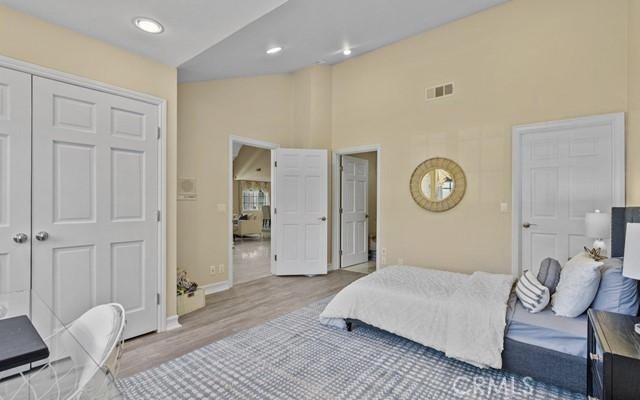 bedroom with a closet, lofted ceiling, and light hardwood / wood-style floors