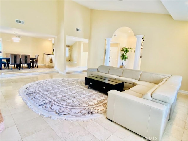 living room with light tile patterned floors and a high ceiling